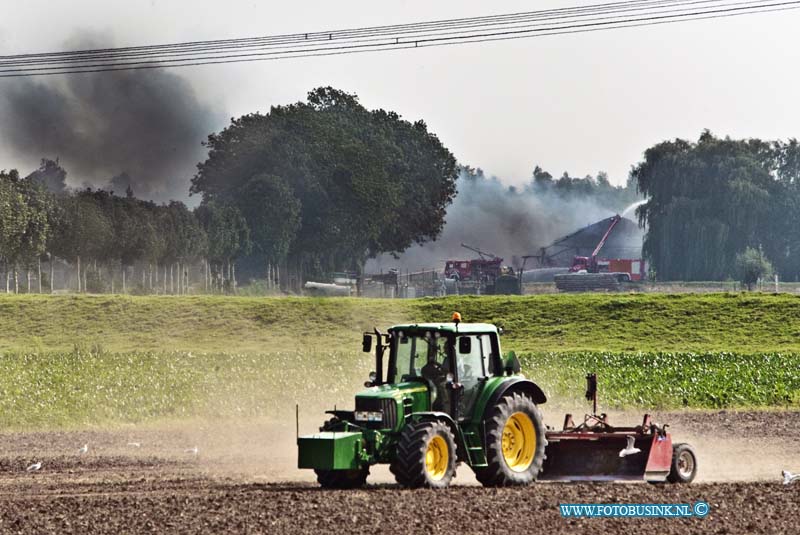 12091002.jpg - FOTOOPDRACHT:Dordrecht:10-09-2012:Foto: Deze boer gaat gewoon door met zijn werkzaamheden op t land terwijl de brandweer druk is met blussen van de boederij.Gebouw brand hooischuur zeer  Grote brand GRIP2 Noorderelsweg 7 Dordrecht bij de frima van Pelt.Deze digitale foto blijft eigendom van FOTOPERSBURO BUSINK. Wij hanteren de voorwaarden van het N.V.F. en N.V.J. Gebruik van deze foto impliceert dat u bekend bent  en akkoord gaat met deze voorwaarden bij publicatie.EB/ETIENNE BUSINK